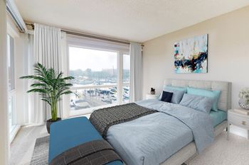 A bedroom with a large bed and a view of a pool and trees outside the window.