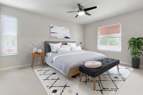 Pleasanton apartment for rent - A bedroom with a large bed, a ceiling fan, and a rug on the floor at Valley Plaza Villages, California, 94566