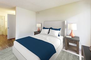 Northridge apartment for rent - A bedroom with a large bed and a nightstand with a lamp at Village Pointe Apartments, Northridge, California
