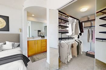 A bedroom with a large bed and a walk-in closet.