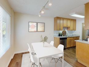Pleasanton apartment for rent - A white dining table with four chairs is in a kitchen with wooden cabinets at Pleasanton Glen Apartments, Pleasanton, California