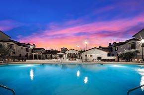Camarillo townhouse for rent - A large swimming pool in front of a building with lights on at The Villas at Anacapa Canyon, Camarillo, 93012