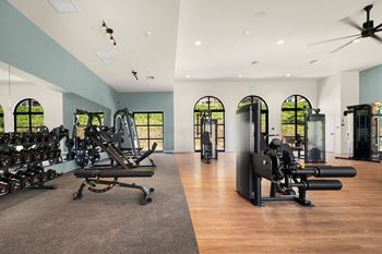 A gym with a variety of equipment including treadmills, weights, and exercise machines.