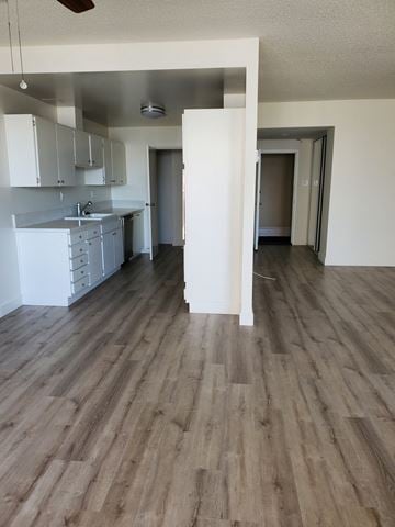Long Beach apartment for rent - an open kitchen and living room with wooden floors and white cabinets