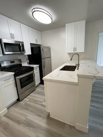 Los Angeles apartment for rent - an overhead view of a kitchen with white cabinets and black appliances