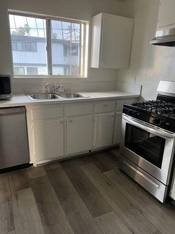Los Angeles apartment for rent - a kitchen with white cabinets and a stove and a sink