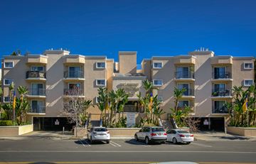 Los Angeles apartment for rent - a large apartment building with cars parked in front of it