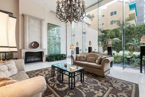 Los Angeles apartment for rent - A lobby with a fireplace, a sofa, a coffee table, and a chandelier.