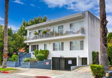 West Hollywood apartment for rent - a white house with a driveway and a street in front of it