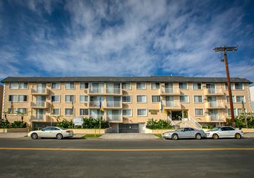 Los Angeles apartment for rent - a large apartment building with cars parked in front of it