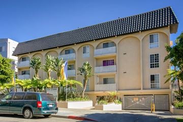 Los Angeles apartment for rent - a van parked in front of an apartment building with palm trees
