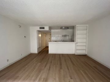Los Angeles apartment for rent - an empty living room and kitchen with wood flooring and white walls