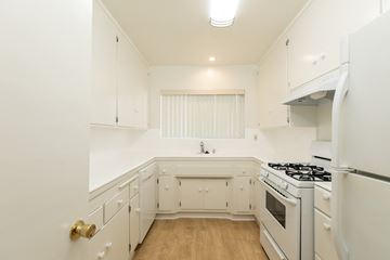 Los Angeles apartment for rent - a kitchen with white cabinets and a stove and a refrigerator