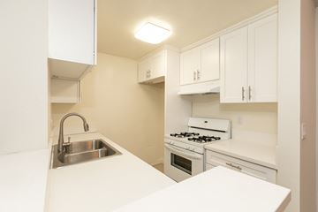 Los Angeles apartment for rent - a kitchen with white cabinets and white counter tops and a sink