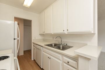 Los Angeles apartment for rent - a kitchen with white cabinets and a sink and a refrigerator