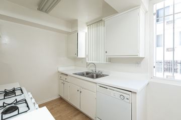 Los Angeles apartment for rent - a kitchen with white cabinets and a sink and a window