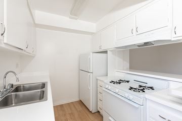 Los Angeles apartment for rent - a kitchen with white appliances and white cabinets and a sink
