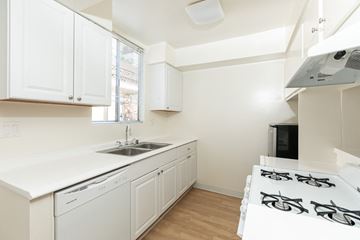 Los Angeles apartment for rent - a kitchen with white cabinets and a sink and a stove