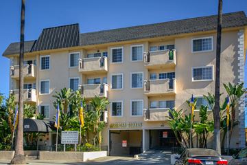 Los Angeles apartment for rent - a large apartment building with palm trees in front of it