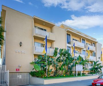 Los Angeles apartment for rent - a large apartment building with palm trees in front of it