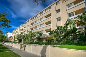 Beverly Hills apartment for rent - a large building with palm trees in front of it on a sidewalk