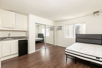 Los Angeles apartment for rent - a bedroom with a bed and a kitchen with a sliding glass door