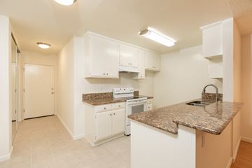 Los Angeles apartment for rent - a kitchen with white cabinets and granite counter tops and a sink
