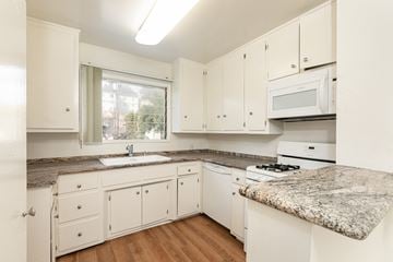 West Hollywood apartment for rent - a kitchen with white cabinets and granite counter tops and white appliances