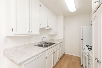 Los Angeles apartment for rent - a kitchen with white cabinets and marble counter tops and a sink