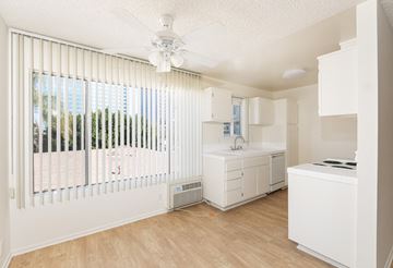 Los Angeles apartment for rent - a renovated kitchen with white cabinets and white appliances and a ceiling fan