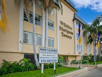 Los Angeles apartment for rent - a now leasing sign in front of a building with palm trees