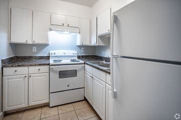 Knoxville apartment for rent - A kitchen with white cabinets and a granite countertop.