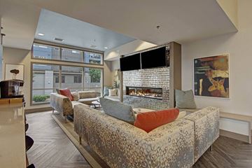 Shoreline apartment for rent - A modern living room with a large couch and a fireplace.