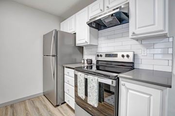 Mountlake Terrace apartment for rent - A modern kitchen with a stainless steel refrigerator and a stove top oven.