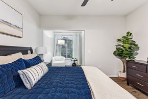 Austin apartment for rent - A bedroom with a large bed and a plant on the side table at Stone Oak @ Parmer, Austin, TX