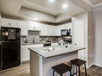 A kitchen with white cabinets and a counter top