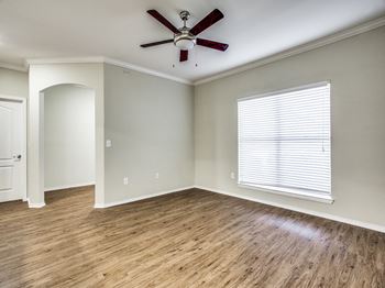 A living room with hardwood floors and a ceiling fan