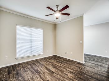 A bedroom with hardwood floors and a ceiling fan