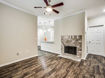 A living room with a fireplace and a ceiling fan