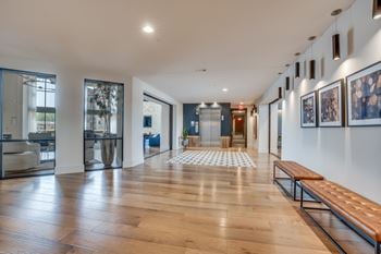 A long hallway with a bench and pictures on the wall.