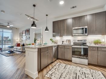 A modern kitchen with a white island and stainless steel appliances.