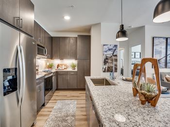 A modern kitchen with a stainless steel refrigerator and wooden cabinets.