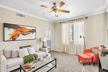 Goodyear apartment for rent - A living room with a white couch, a red chair, and a painting on the wall.