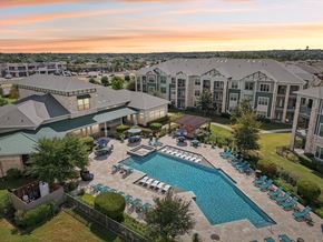 Hutto apartment for rent - A large outdoor swimming pool surrounded by lounge chairs and umbrellas.at North Creek, Hutto