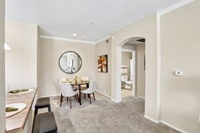 Goodyear apartment for rent - A dining room with a round mirror and a dining table with chairs.