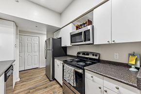 Austin apartment for rent - A kitchen with a stove top oven and a microwave above it. at Stone Oak @ Parmer, Austin