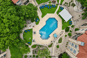 Georgetown apartment for rent - A large swimming pool surrounded by a grassy area and trees.