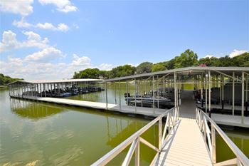 A dock at a lake with boats docked at a marina