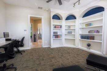 A home office with a desk and shelves with books