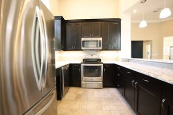 A kitchen with black cabinets and stainless steel appliances